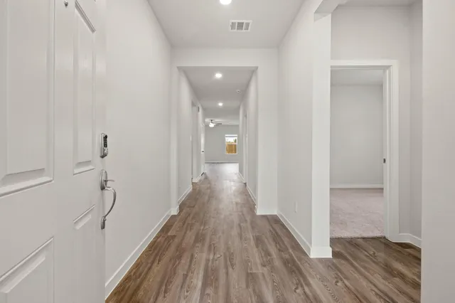 a view of hallway with wooden floor