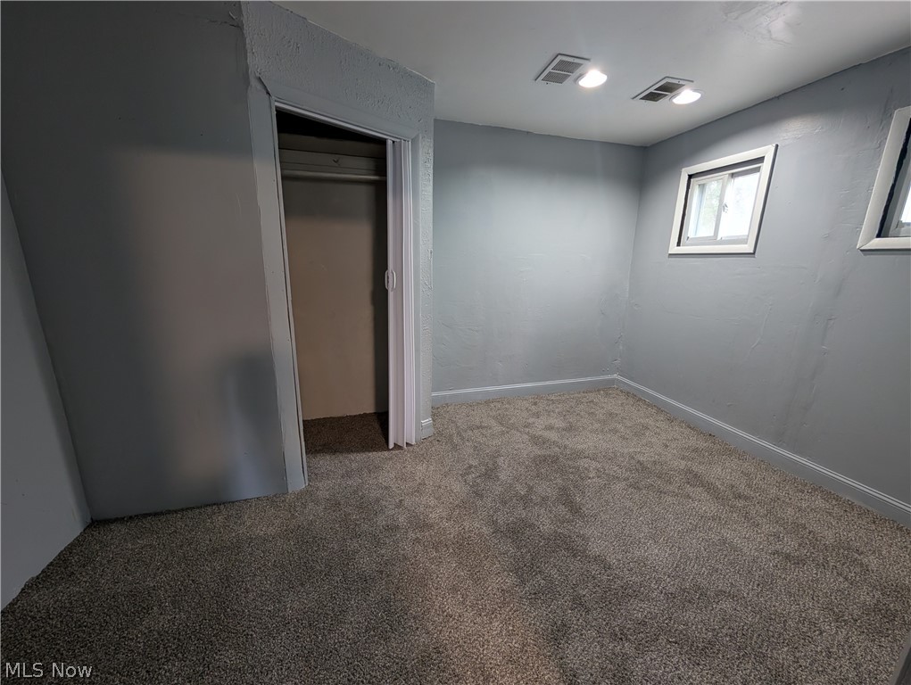 475 East 146th Street Cleveland, OH 44110 - Photo 20 of 28 Spacious room featuring plush gray carpeting, light gray wall finishes, a built-in closet with bi-fold doors, two recessed ceiling lights, and two windows with white trim