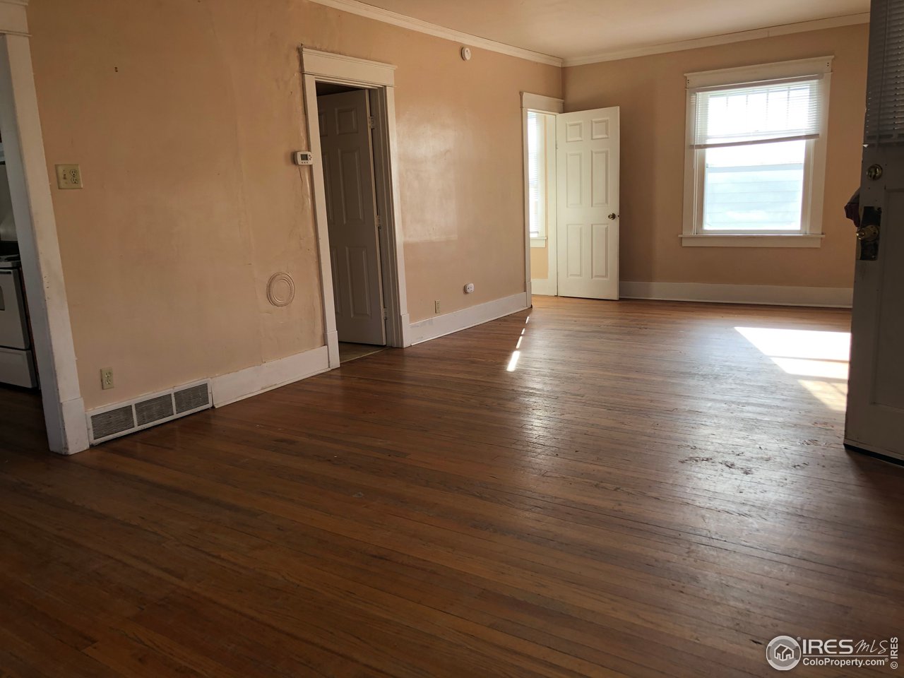 1458 10th Street Greeley, CO 80631 - Photo 3 of 21 an empty room with wooden floor and windows