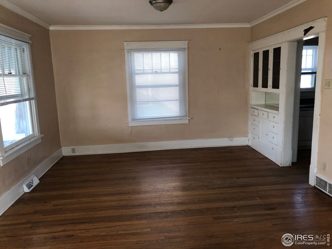 1458 10th Street Greeley, CO 80631 - Photo 7 of 21 a view of an empty room with wooden floor and a window