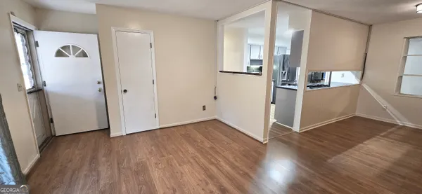 an empty room with wooden floor and windows