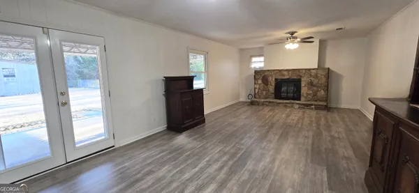 a view of a livingroom with wooden floor a fireplace and window