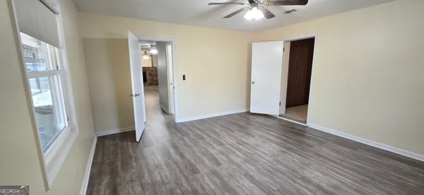 an empty room with a window and wooden floor