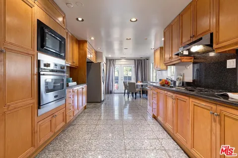 a large kitchen with stainless steel appliances lots of counter space and a sink