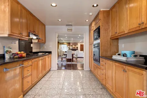 a kitchen with stainless steel appliances granite countertop a refrigerator and a stove top oven