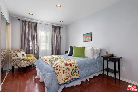 a bedroom with a bed and wooden floor