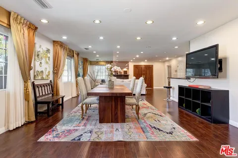 a living room with stainless steel appliances furniture and a flat screen tv