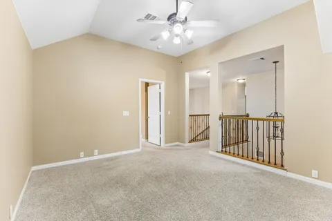 a view of a hallway with a chandelier fan