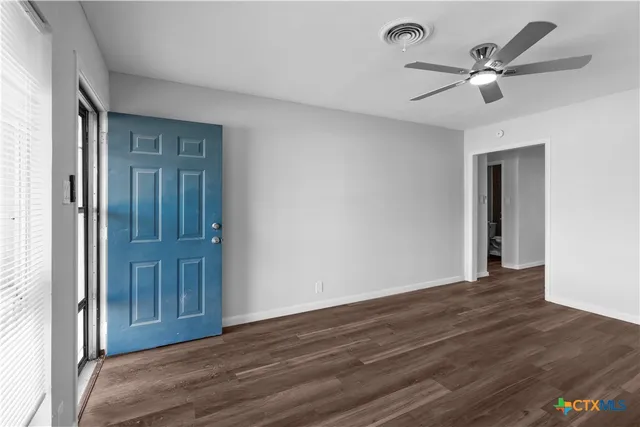 a view of a livingroom with a ceiling fan wooden floor and a ceiling fan