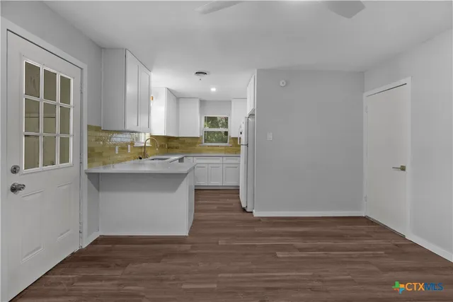 a view of kitchen with wooden floor and electronic appliances