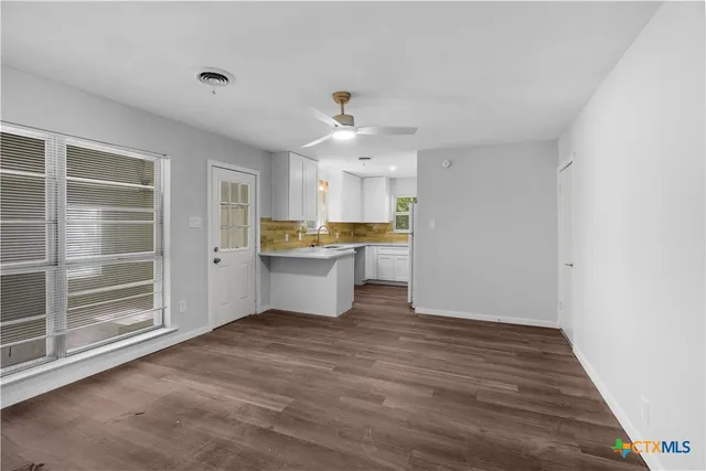 a view of a kitchen with a sink cabinets and wooden floor