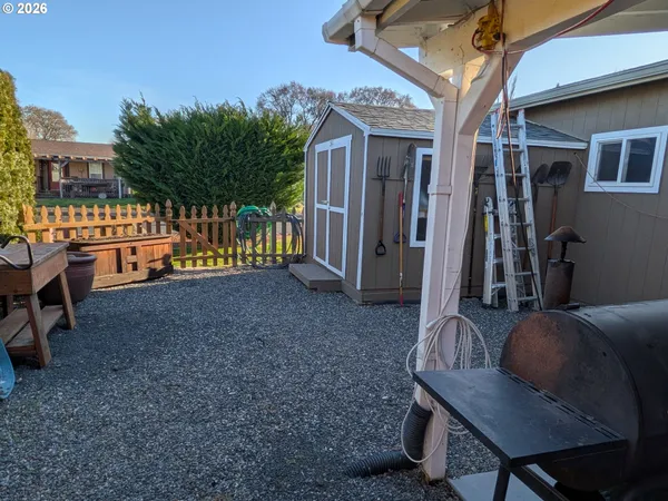 a backyard of a house with barbeque oven table and chairs