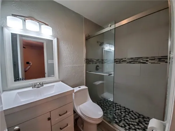 a bathroom with a toilet a sink and shower
