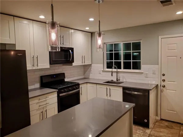 a kitchen with a sink stove and microwave