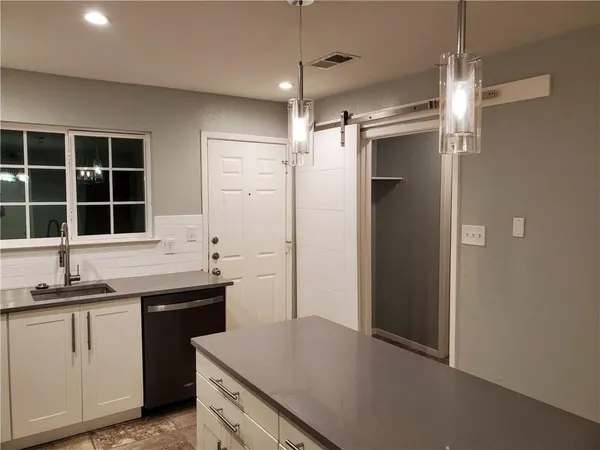 a kitchen with granite countertop a sink and cabinets