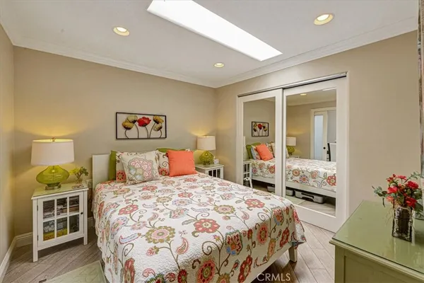 a bedroom with a bed and a large mirror on the dresser