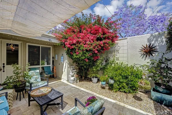 a view of a backyard with sitting area and garden