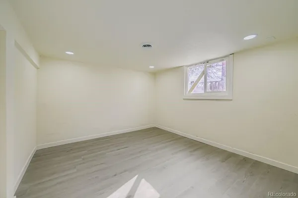 an empty room with wooden floor and painting on the wall