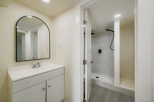 a bathroom with a shower sink and mirror