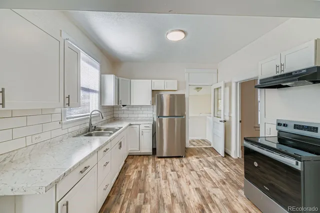 a kitchen with white cabinets and stainless steel appliances