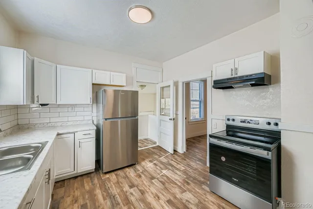 a kitchen with a refrigerator stove and wooden cabinets