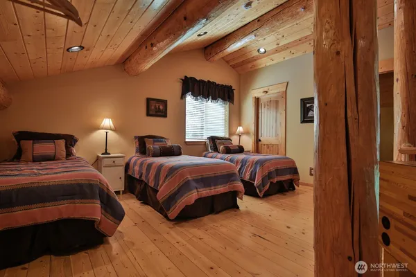 a bedroom with two beds and a lamp