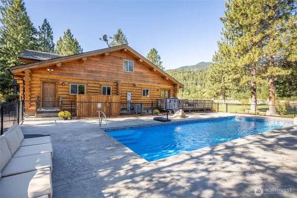 a view of a house with pool and sitting area