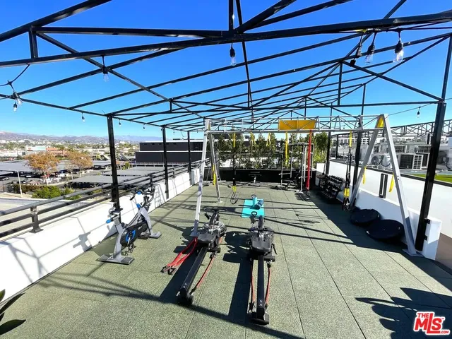 a view of a patio with a dining table and chairs under an umbrella