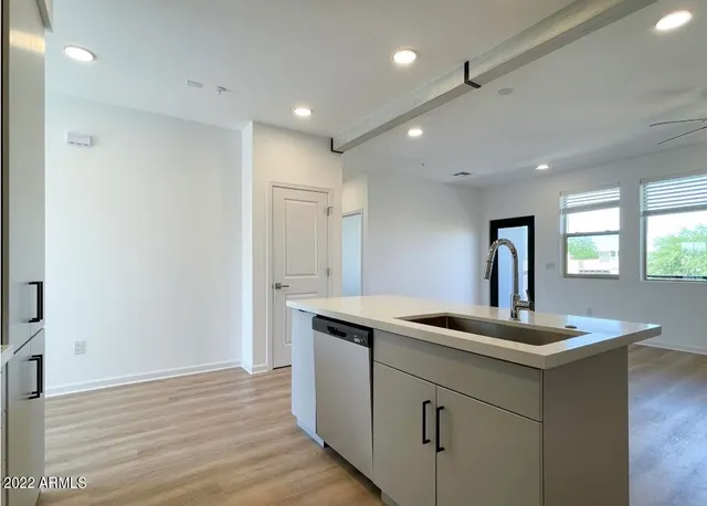 a kitchen with kitchen island a sink stainless steel appliances and window
