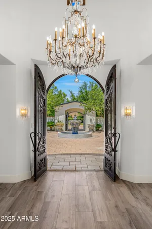 a view of a livingroom with furniture a chandelier and wooden floor