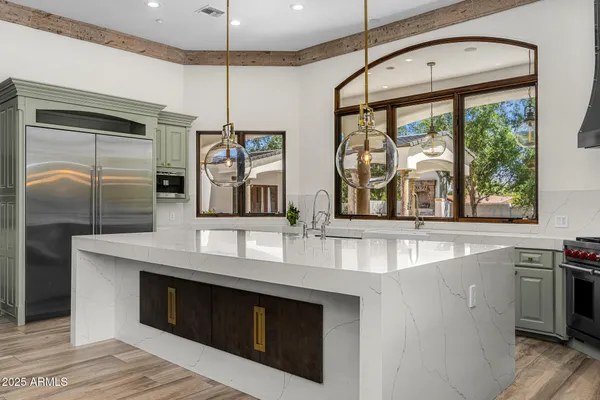 a kitchen with stainless steel appliances granite countertop a sink a stove and a refrigerator