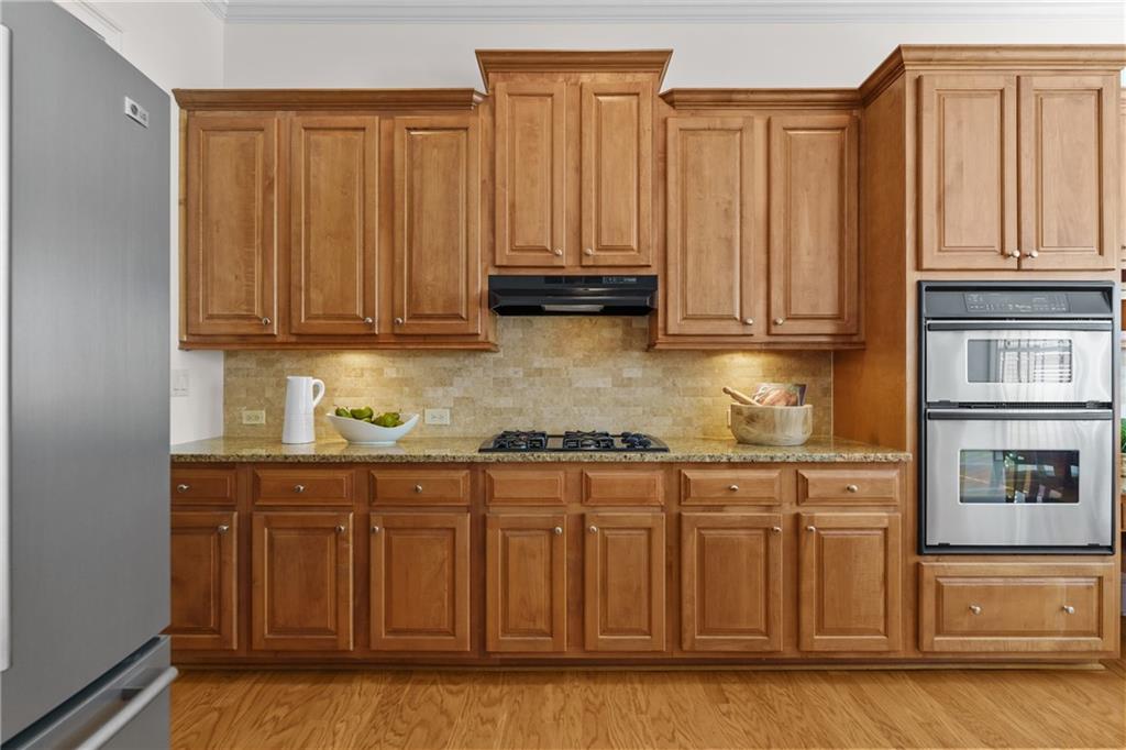 11945 Dancliff Trace Alpharetta, GA 30009 - Photo 11 of 48 a kitchen with stainless steel appliances granite countertop a refrigerator and cabinets