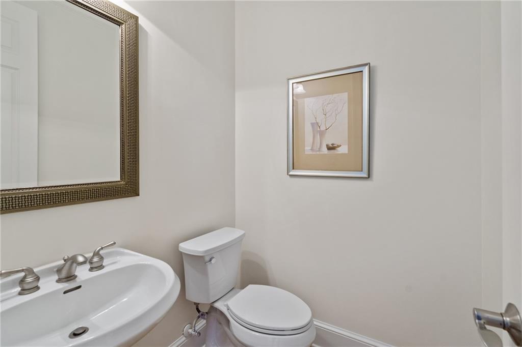 11945 Dancliff Trace Alpharetta, GA 30009 - Photo 17 of 48 a bathroom with a toilet a sink and mirror