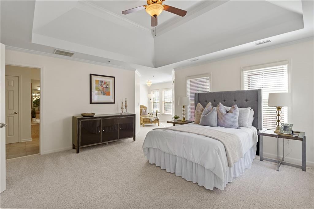 11945 Dancliff Trace Alpharetta, GA 30009 - Photo 21 of 48 a spacious bedroom with a bed and a chandelier