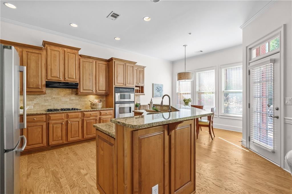 11945 Dancliff Trace Alpharetta, GA 30009 - Photo 8 of 48 a kitchen with stainless steel appliances granite countertop sink stove top oven and cabinets
