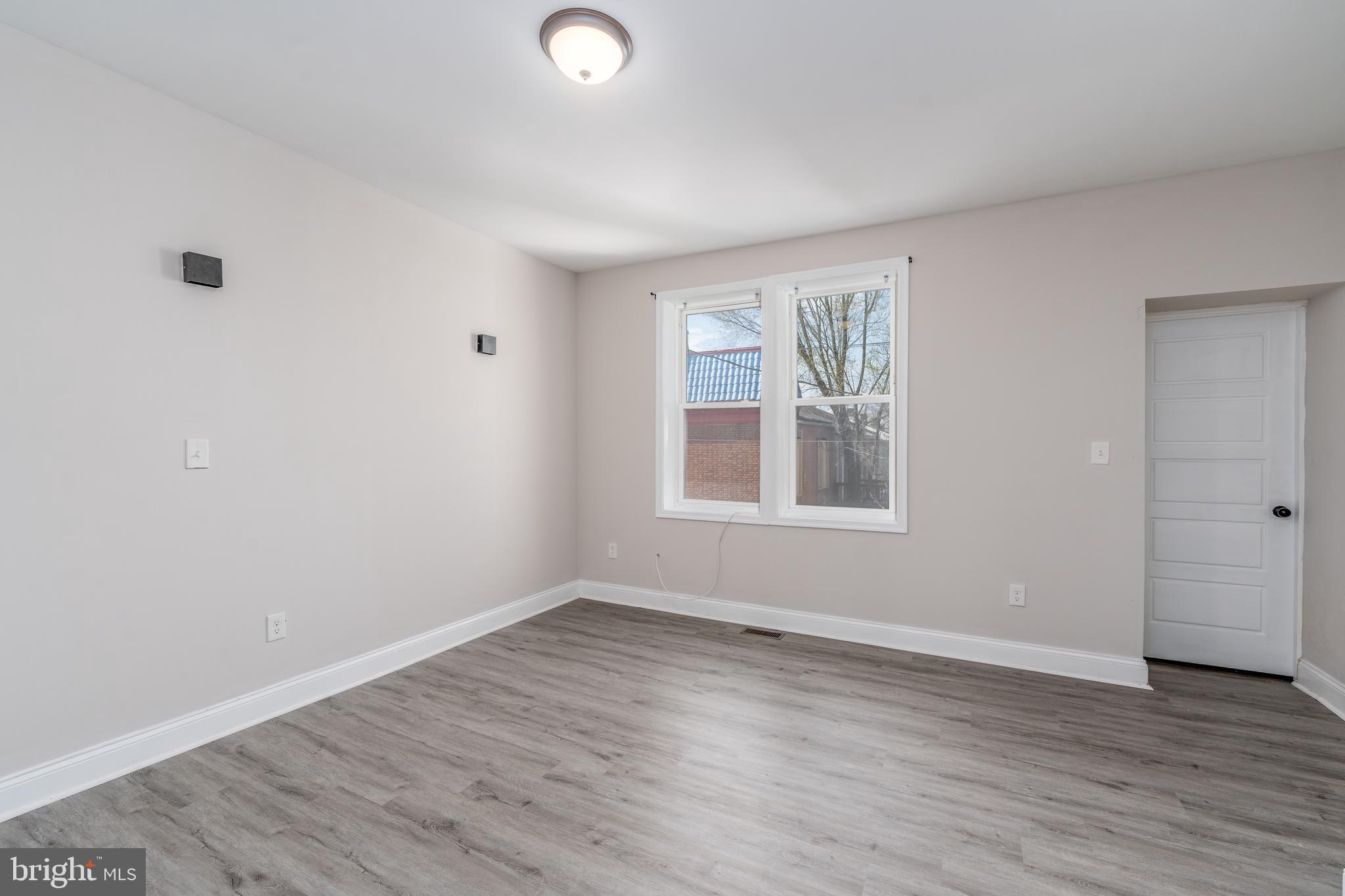 3506 Reisterstown Road Baltimore, MD 21215 - Photo 15 of 32 an empty room with wooden floor and windows