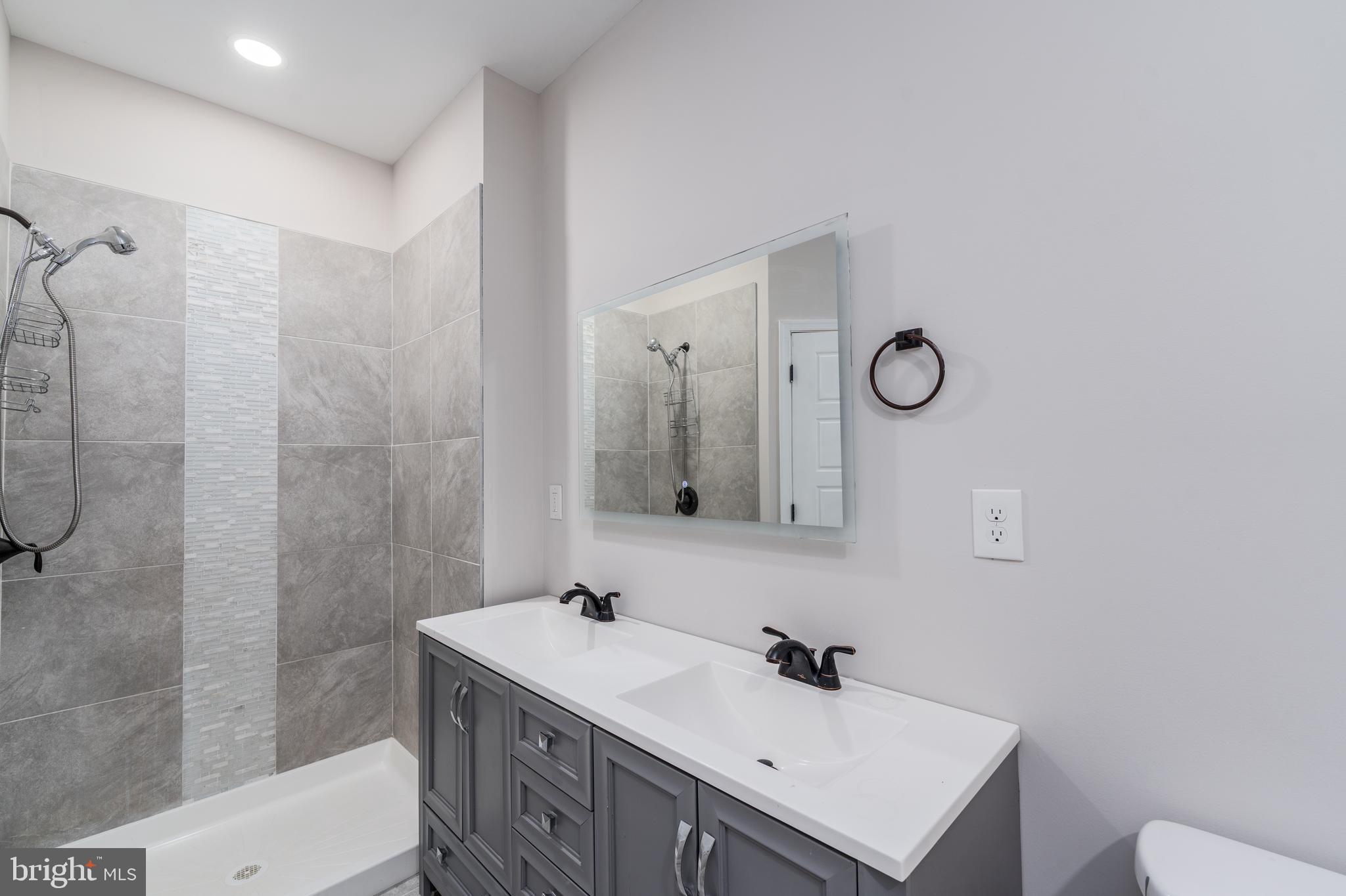 3506 Reisterstown Road Baltimore, MD 21215 - Photo 16 of 32 a bathroom with a sink a toilet and shower