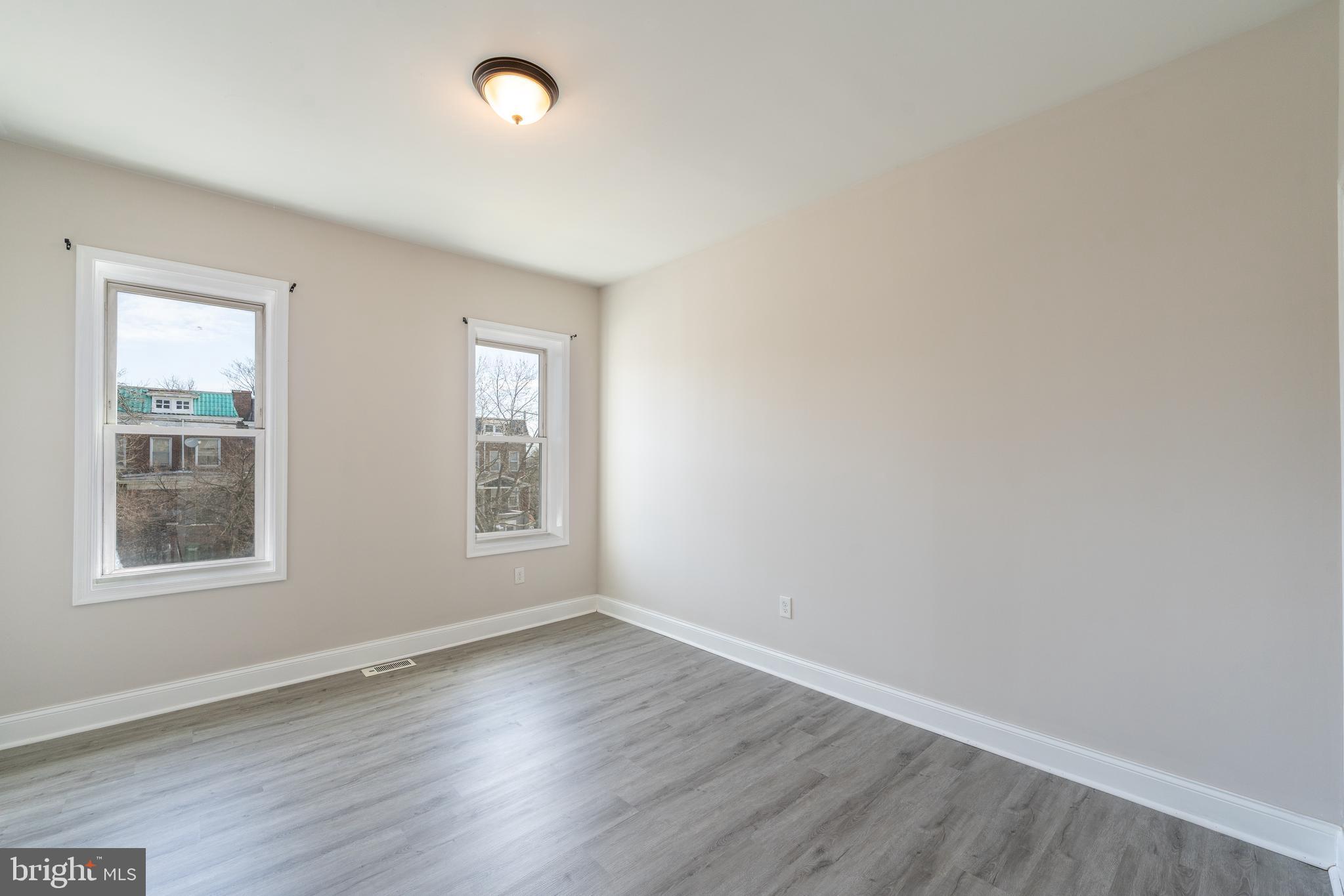 3506 Reisterstown Road Baltimore, MD 21215 - Photo 19 of 32 an empty room with wooden floor and windows