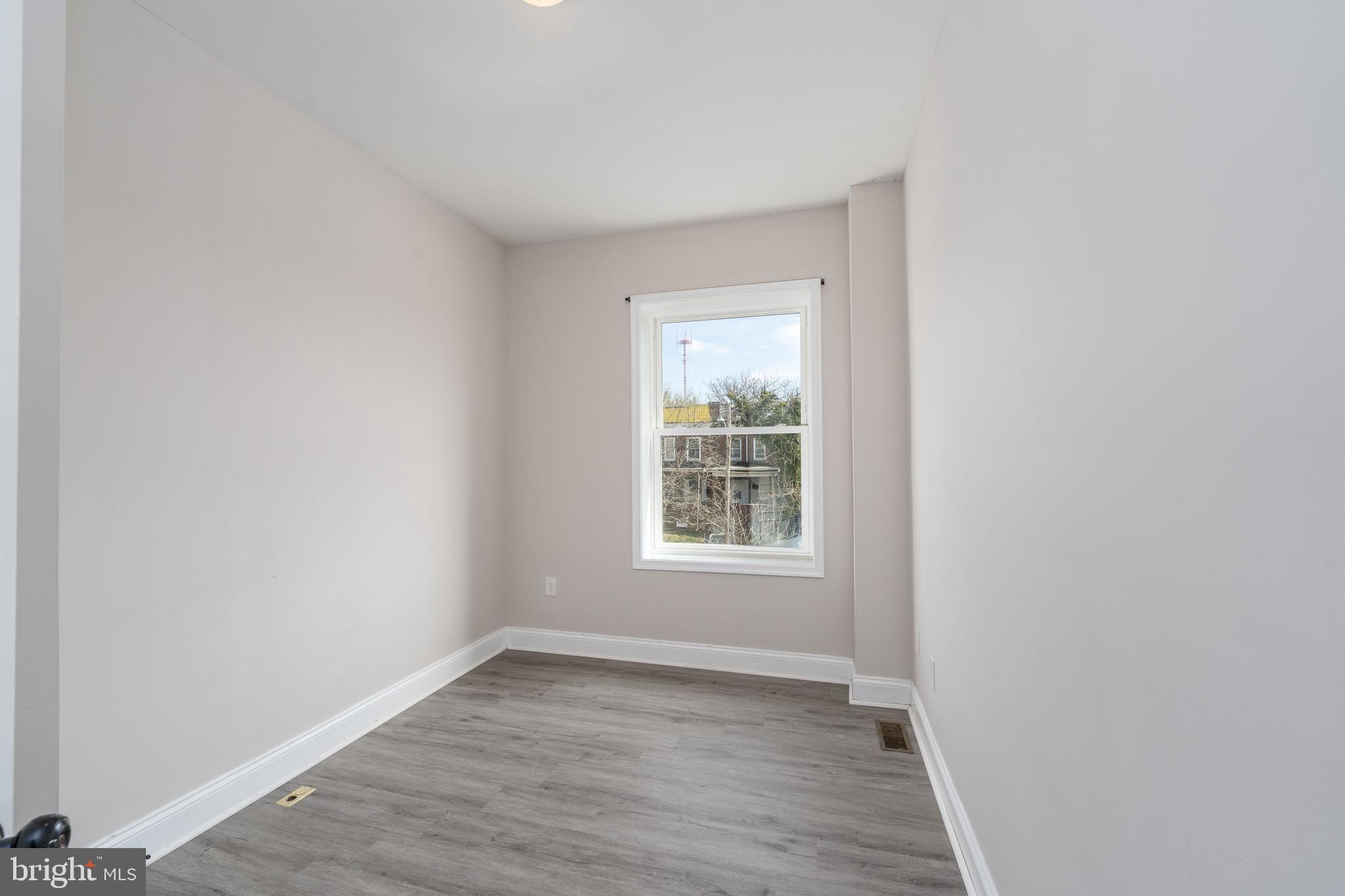 3506 Reisterstown Road Baltimore, MD 21215 - Photo 21 of 32 an empty room with wooden floor and windows