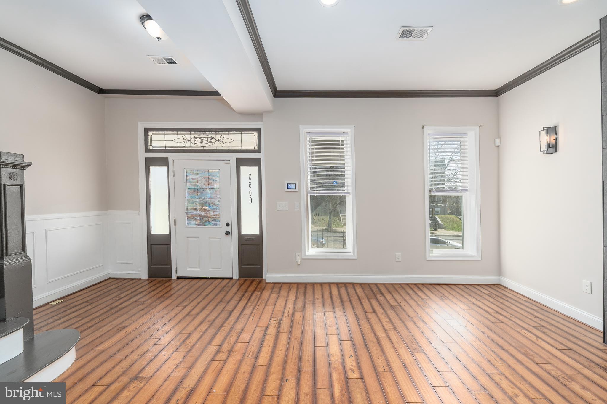 3506 Reisterstown Road Baltimore, MD 21215 - Photo 4 of 32 an empty room with wooden floor and windows