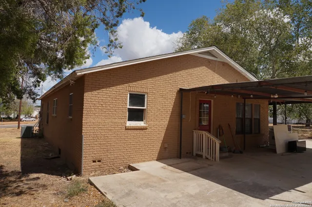 a view of a patio with a table and chairs under an umbrella