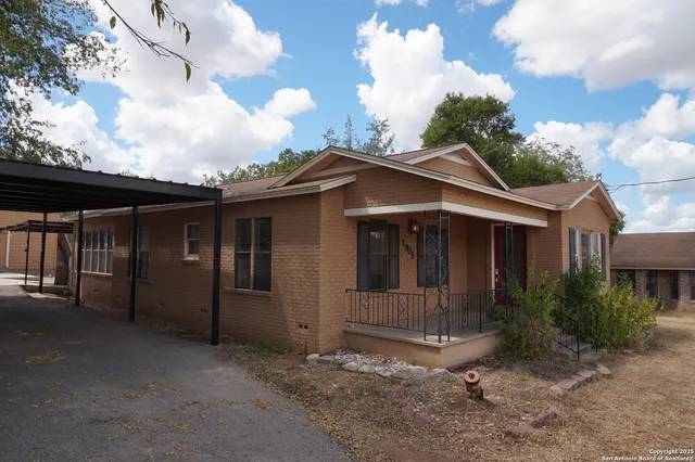 a view of a house with a small yard and floor to ceiling window