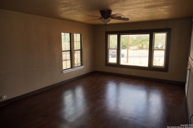 a view of a livingroom with wooden floor and a window
