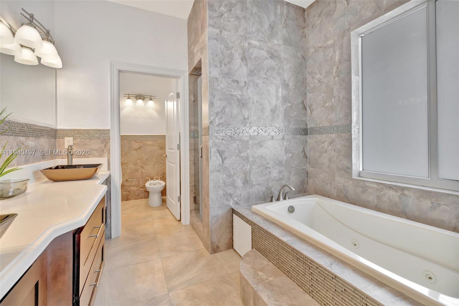 4610 Southwest 178th Avenue Southwest Ranches, FL 33331 - Photo 51 of 100 a bathroom with a tub a sink and a large mirror