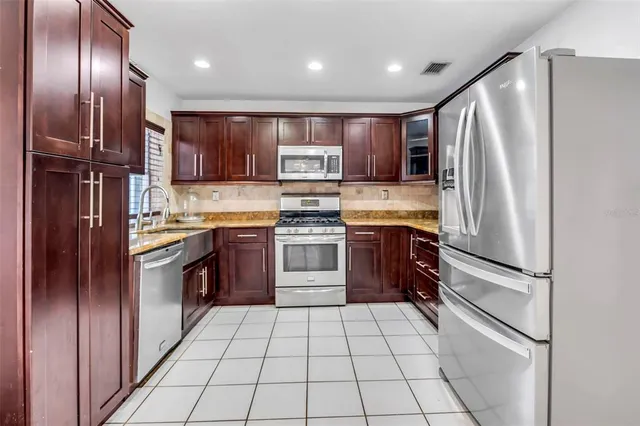 a kitchen with stainless steel appliances granite countertop a refrigerator stove and oven