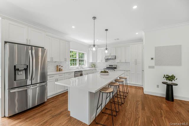 1 Kewanee Road New Rochelle, NY 10804 - Photo 10 of 36 a kitchen with stainless steel appliances a refrigerator a sink dishwasher a stove and white countertops with wooden floor