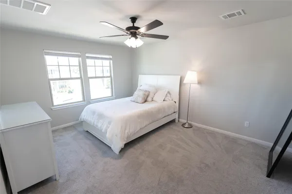 a spacious bedroom with a bed dresser and a window