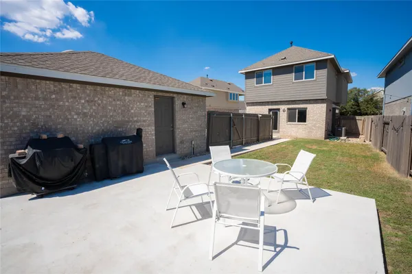 a view of a patio with table and chairs with wooden floor and fence