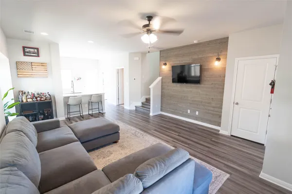 a living room with furniture and a wooden floor