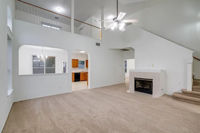 a view of an empty room with window and fireplace